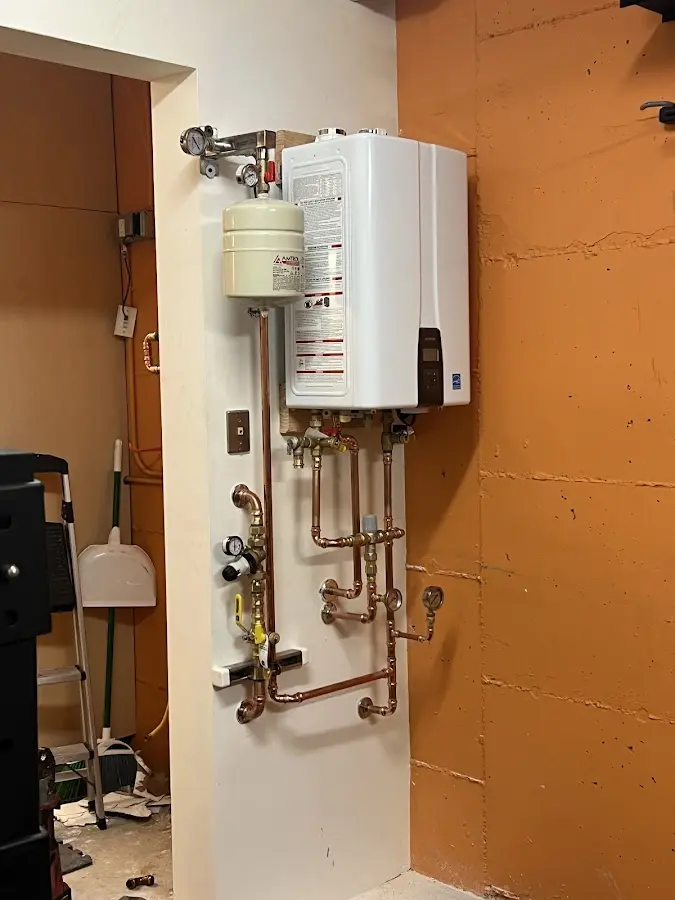 Plumbing technician inspecting water heater connections in Johnson City